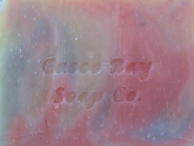 close up of creamy white soap bar with red and blue swirls