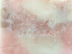 close up of a creamy white bar of soap with pink and brown swirls