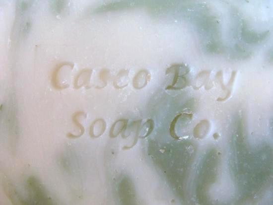 off white soap bar with green swirls