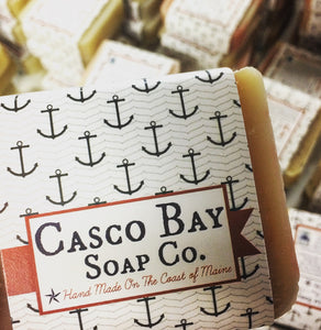 close up of a bar of soap with a white paper label adorned with blue anchors