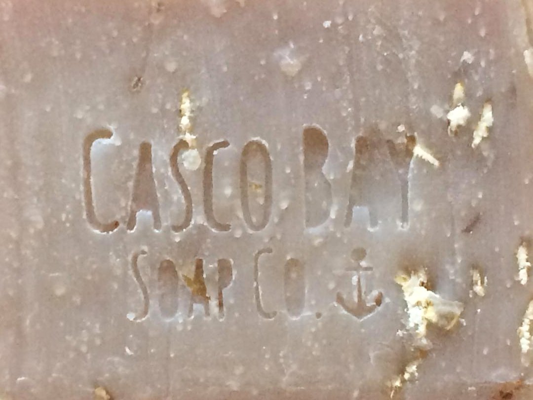 close up of a tan bar of soap with oatmeal flakes