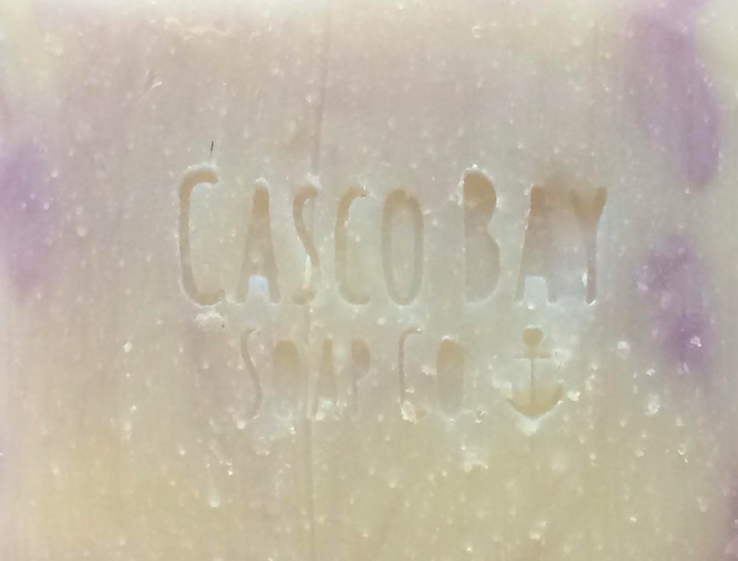 close up of a creamy white bar of soap with purple swirls
