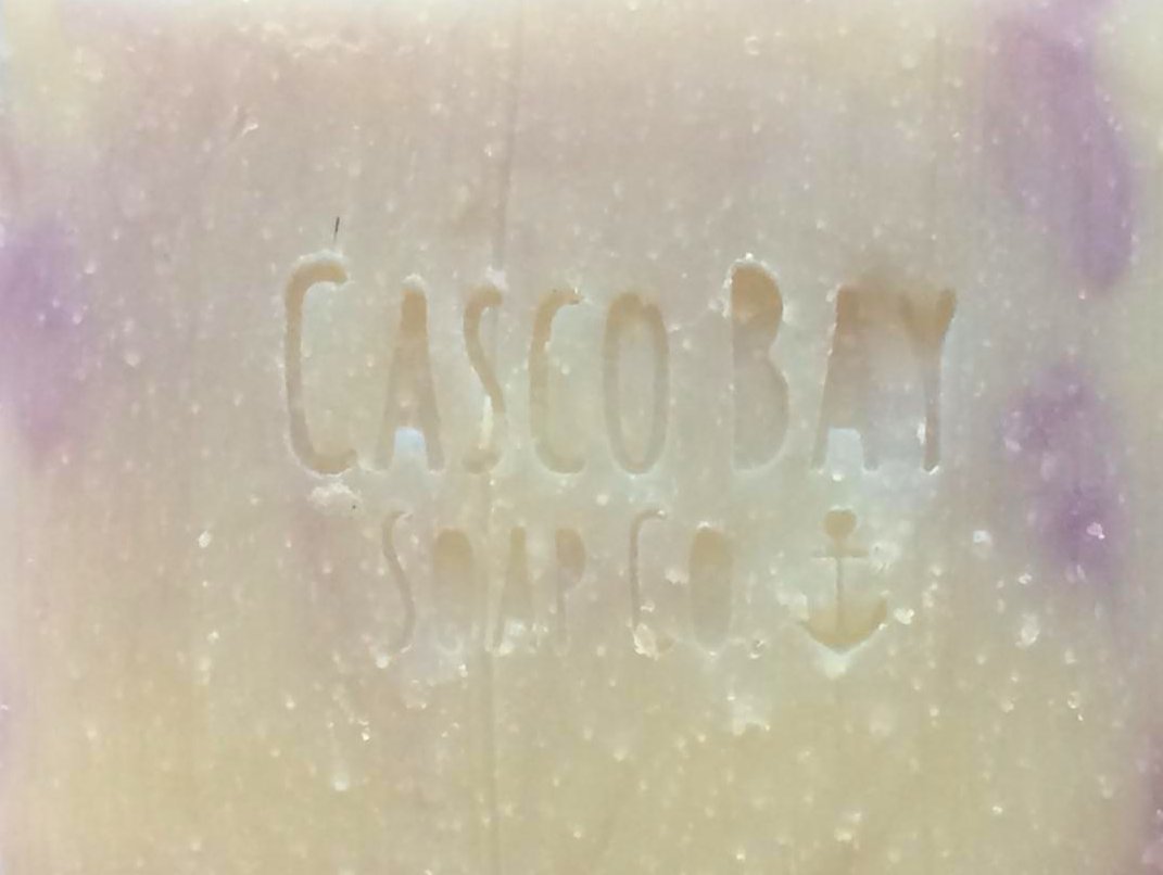 a close up of a creamy white bar of soap with light purple swirls