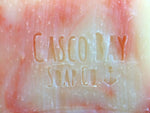 close up of an off white bar of soap with red swirls