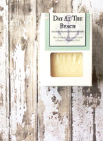 white soap box with a cut out shows a creamy white bar of soap