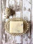 a creamy white bar of soap with flecks of blue, green yellow and pink