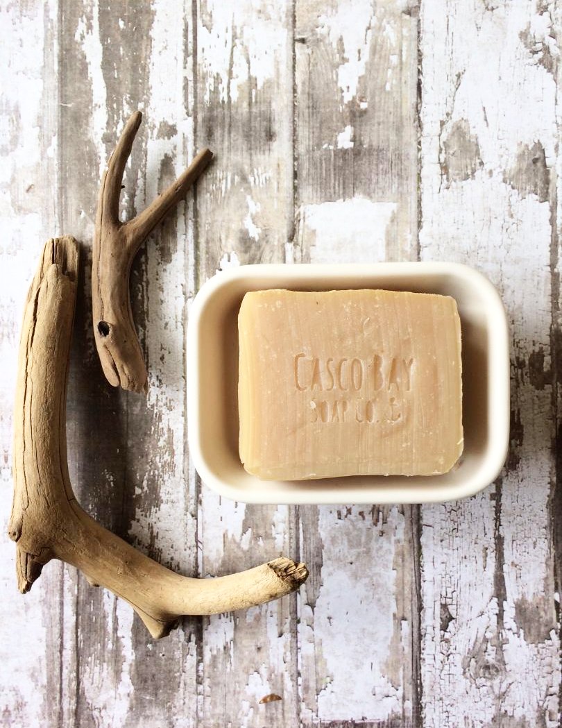 a tan soap bar sits in a soap dish