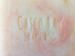 close up of creamy white bar of soap with pink swirls