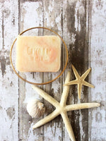 creamy white bar of soap with pink swirls in it