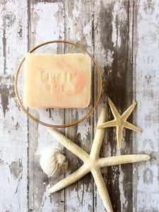 creamy white bar of soap with pink swirls in it