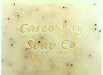 close up of a yellow bar of soap with black flecks