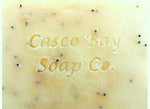 a close up of a yellow bar of soap with black flecks