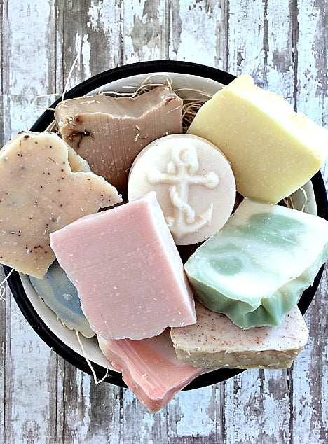 a bowl of many misshaped bars of soap of different colors