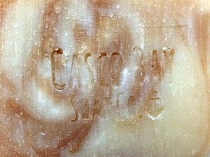 close up of a creamy white bar of soap with brown swirls