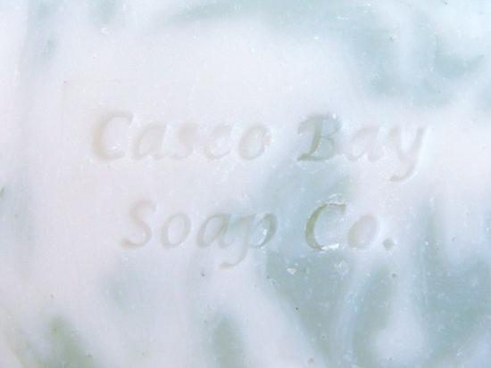close up of a creamy white bar of soap with green swirls