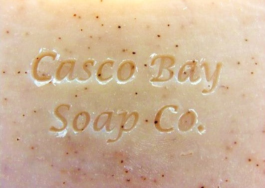 close up of a light tan bar of soap with brown flecks