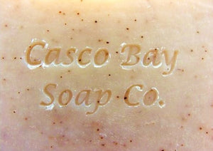 close up of a light tan bar of soap with brown flecks