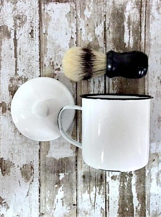 a white mug with a lid sits along side a short brush with a black handle