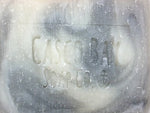 close up of a creamy white bar of soap with grey swirls